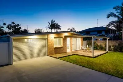 Single-storey home with a garage door at dusk